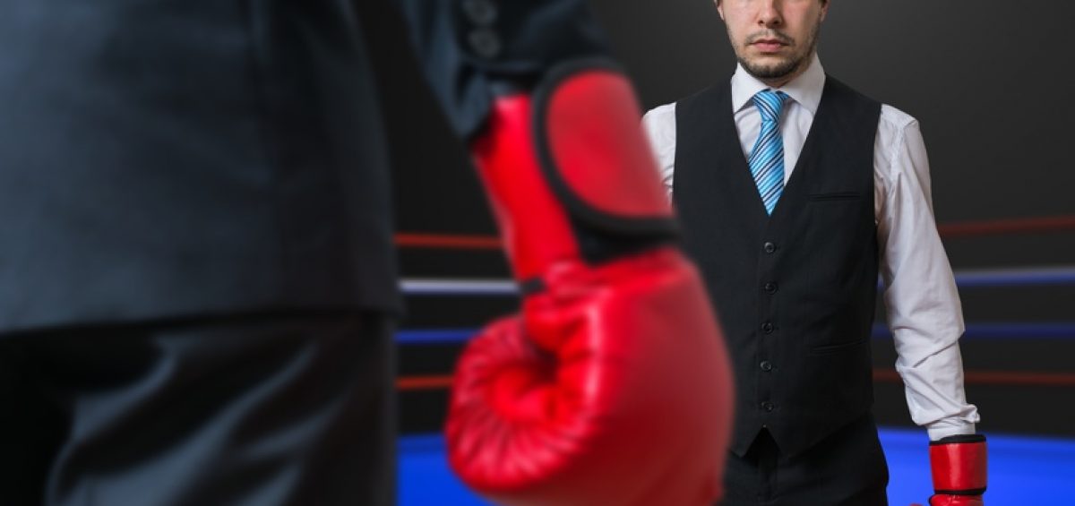 Businessman is boxing with his boss in ring.